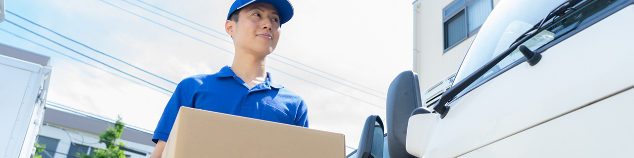 荷物を運ぶ男性とトラック