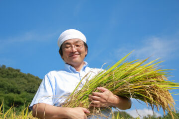 稲を抱えた農家